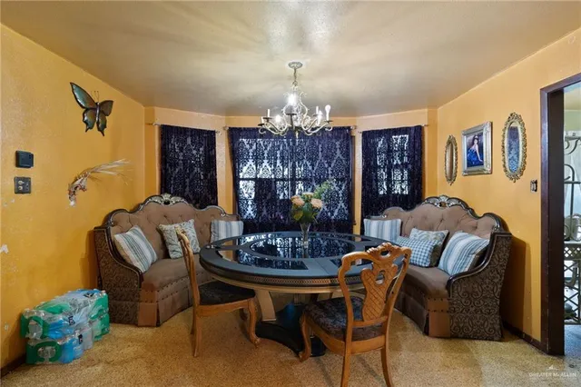 a living room with furniture a dining table and a chandelier
