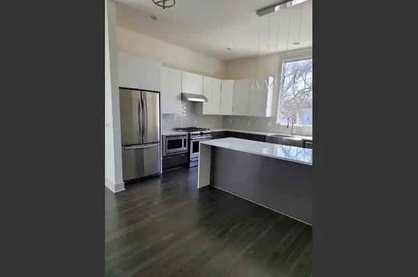 a kitchen with stainless steel appliances granite countertop a refrigerator a stove a sink and a microwave oven