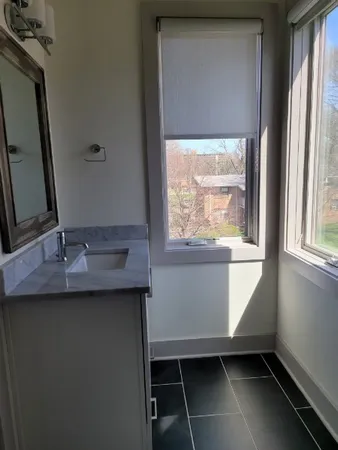 a bathroom with a sink a mirror and window
