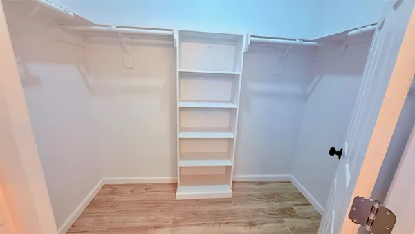 a view of walk in closet with empty racks
