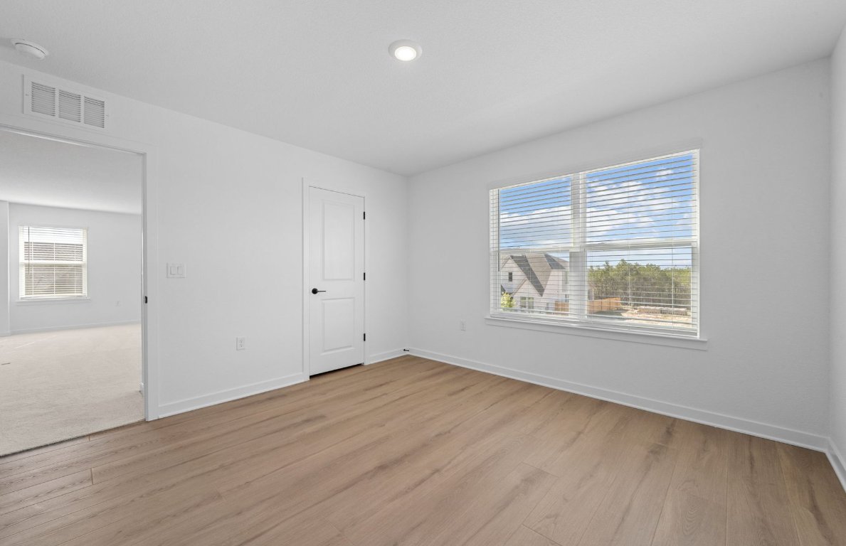 125 Adlai Avenue Georgetown, TX 78633 - Photo 22 of 32 a view of an empty room with wooden floor and a window