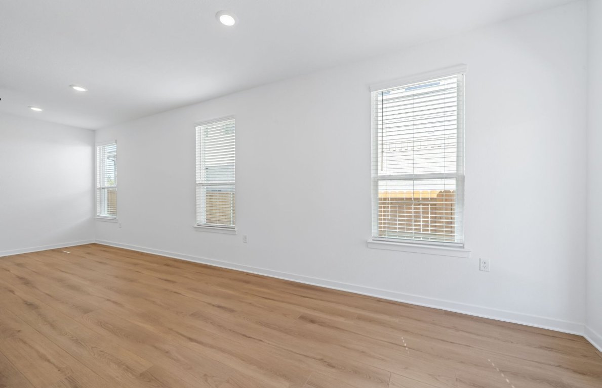 125 Adlai Avenue Georgetown, TX 78633 - Photo 9 of 32 an empty room with wooden floor and windows