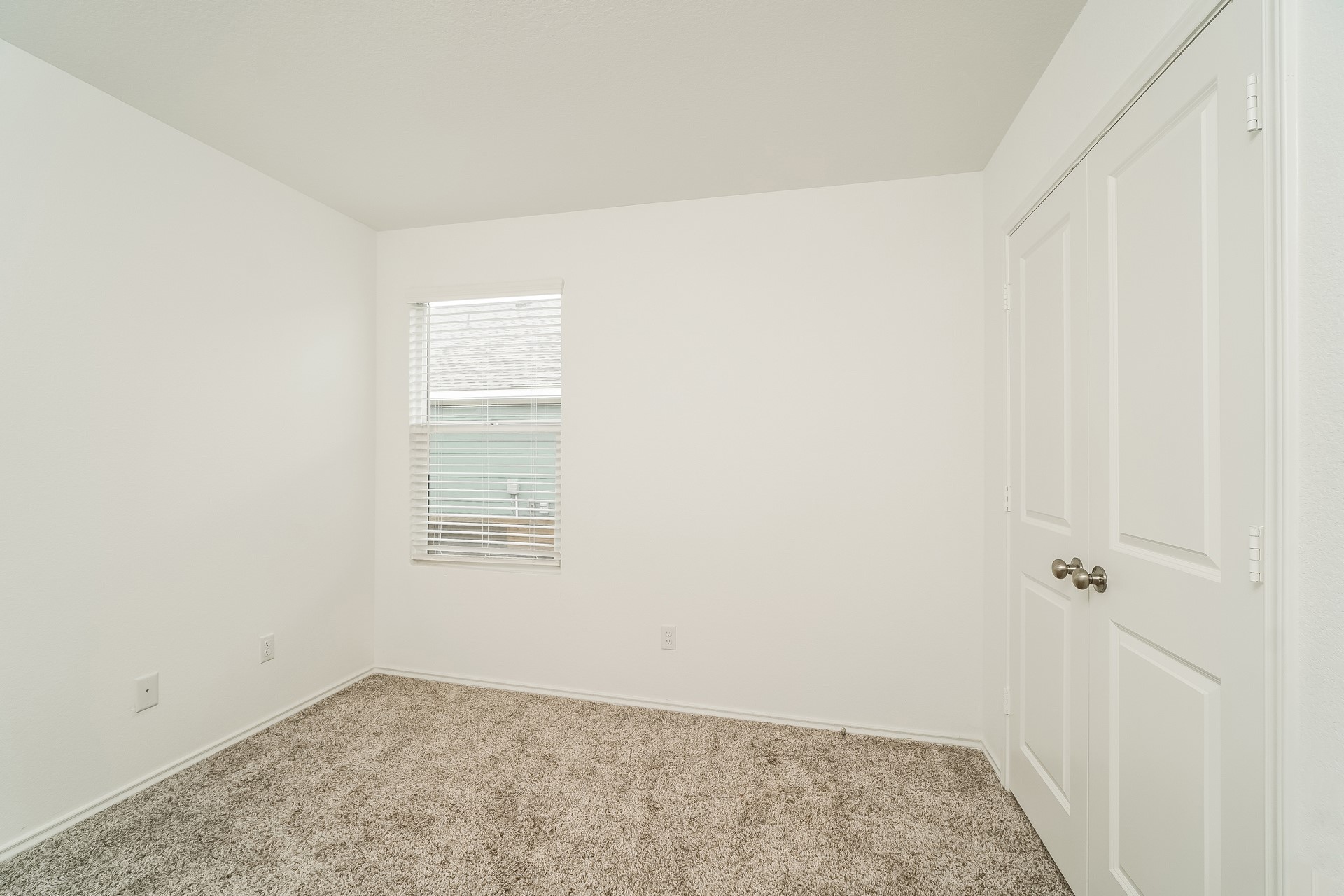 341 Madrid Kyle, TX 78640 - Photo 17 of 27 A well-lit room featuring neutral tones and cozy carpet flooring.
