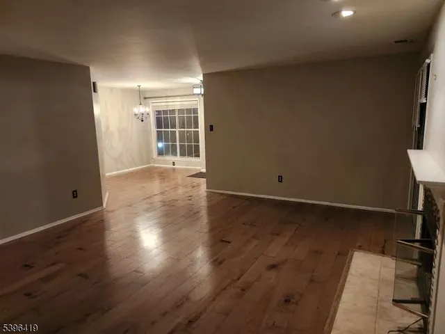 an empty room with wooden floor and a window