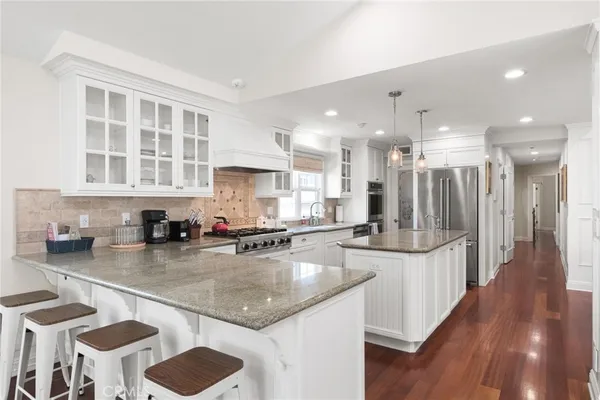 a kitchen with stainless steel appliances granite countertop a sink refrigerator and cabinets