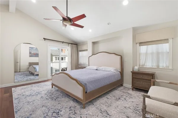 a bedroom with a bed and a dresser with wooden floor