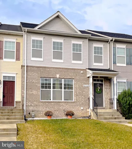 a view of a white house with large windows and a yard
