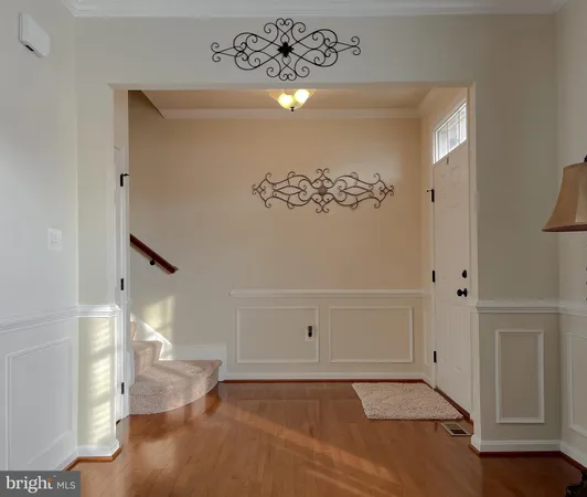 a dining room with wooden floor a chandelier a wooden table and chairs
