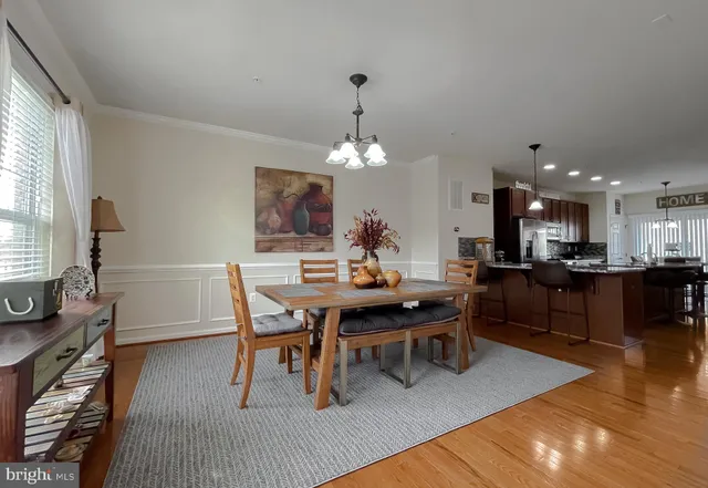 a kitchen with a table chairs a sink a window and stainless steel appliances