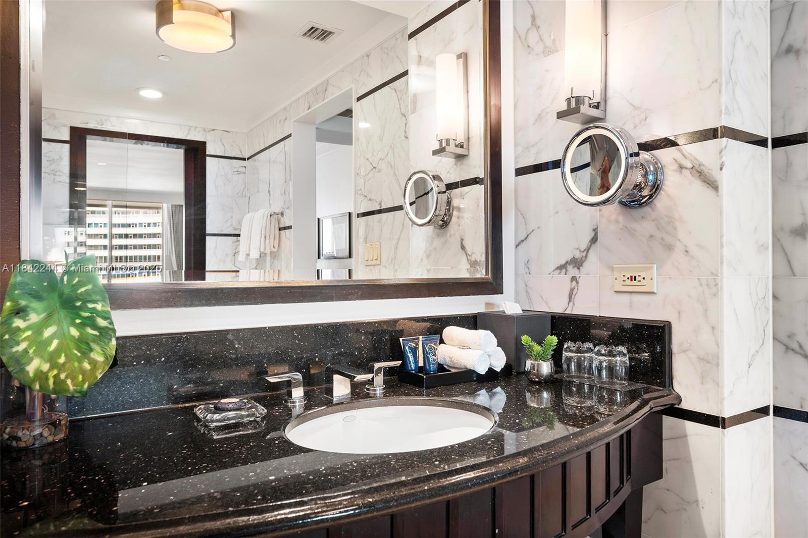 4391 Collins Avenue, Unit 802 Miami Beach, FL 33140 - Photo 36 of 39 a bathroom with a sink and a mirror