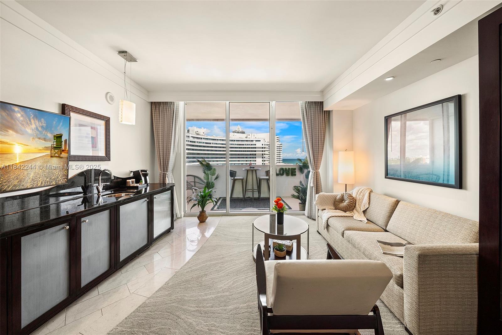 4391 Collins Avenue, Unit 802 Miami Beach, FL 33140 - Photo 6 of 39 a living room with furniture and a flat screen tv