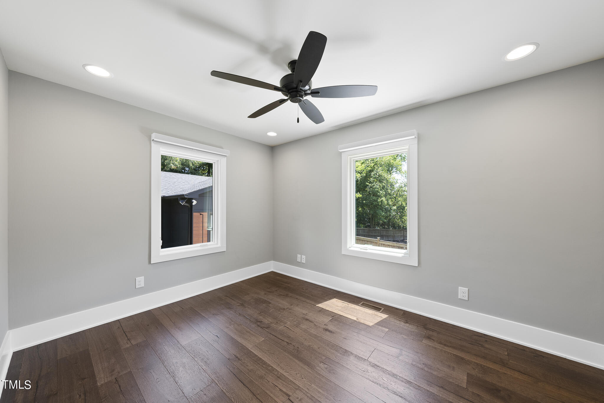 3122 Ashel Street Raleigh, NC 27612 - Photo 16 of 39 an empty room with wooden floor ceiling fan and windows