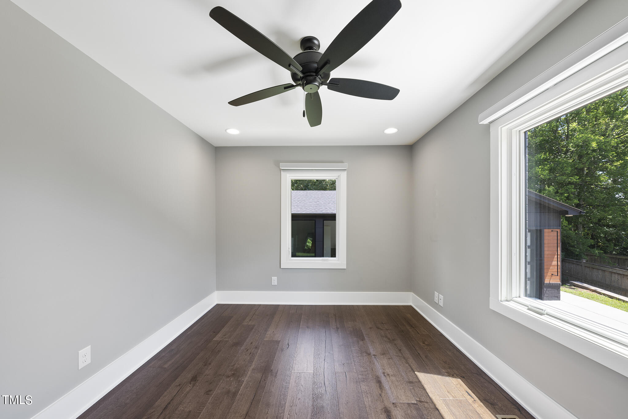 3122 Ashel Street Raleigh, NC 27612 - Photo 17 of 39 an empty room with wooden floor ceiling fan and windows