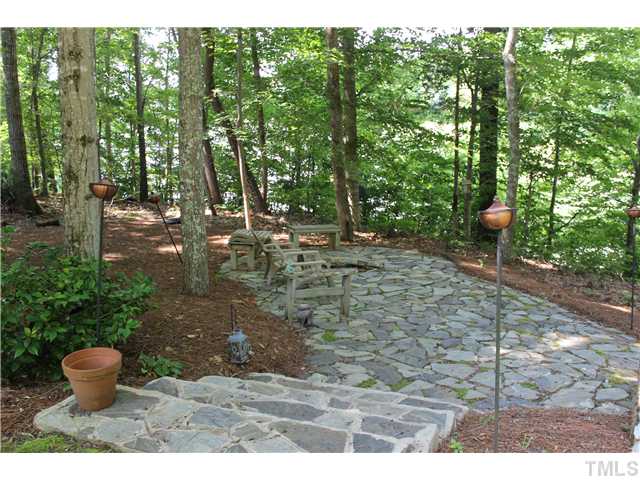 1035 Anglers Way Roxboro, NC 27574 - Photo 24 of 25 Serene Fire Pit stone sitting area to kick back and enjoy the peaceful and private surrounds and your the view of Mayo Lake. Hammock is on the right of this stone patio.