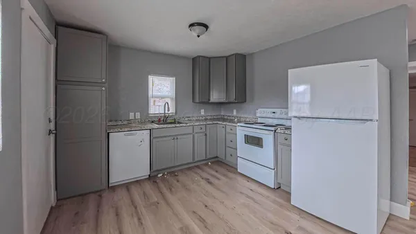 a kitchen with white cabinets and white appliances