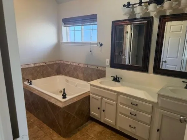 a bathroom with a tub sink and mirror