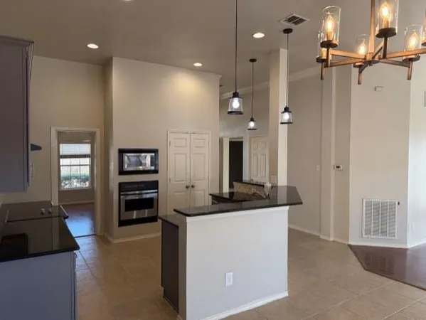 a kitchen view with granite countertop a refrigerator and a stove top oven