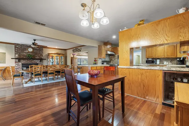a dining room with furniture a chandelier and wooden floor