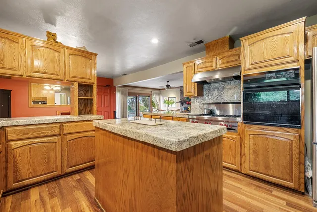 a kitchen with stainless steel appliances granite countertop a stove a sink and a refrigerator