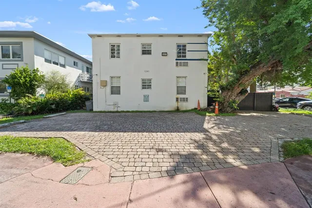 a view of a grey house with a yard