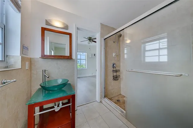 a bathroom with a shower sink and mirror