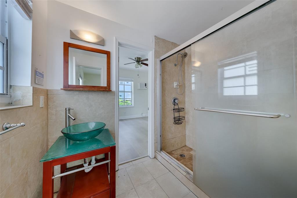 1241 13th Street, Unit 2 Miami Beach, FL 33139 - Photo 7 of 20 a bathroom with a shower sink and mirror