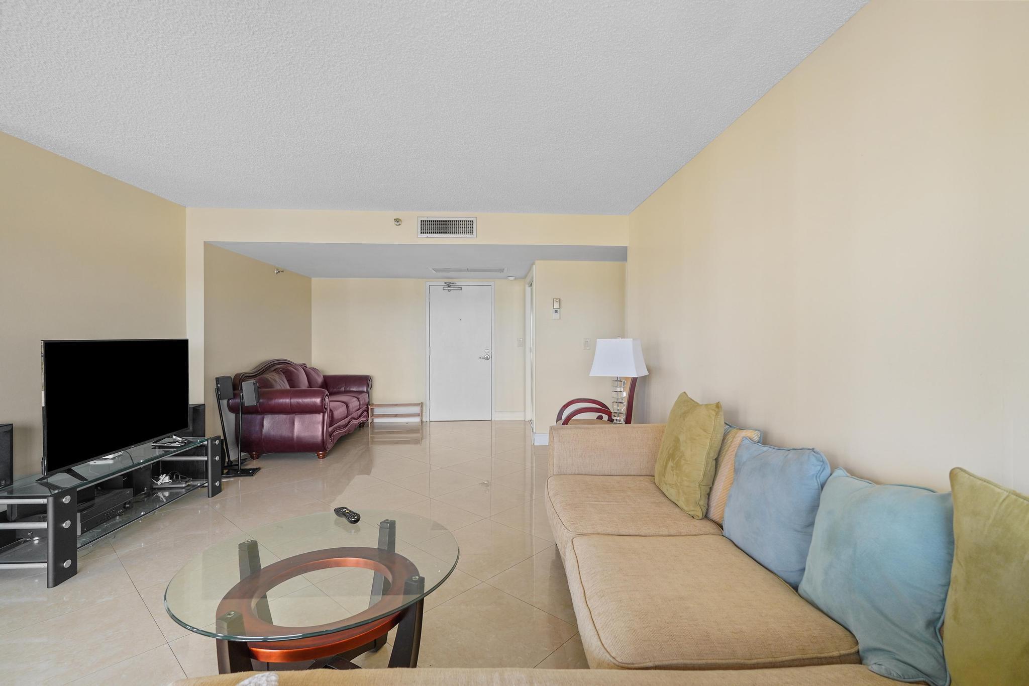 859 Jeffery Street, Unit 506 Boca Raton, FL 33487 - Photo 12 of 80 a living room with furniture a flat screen tv and gym equipment