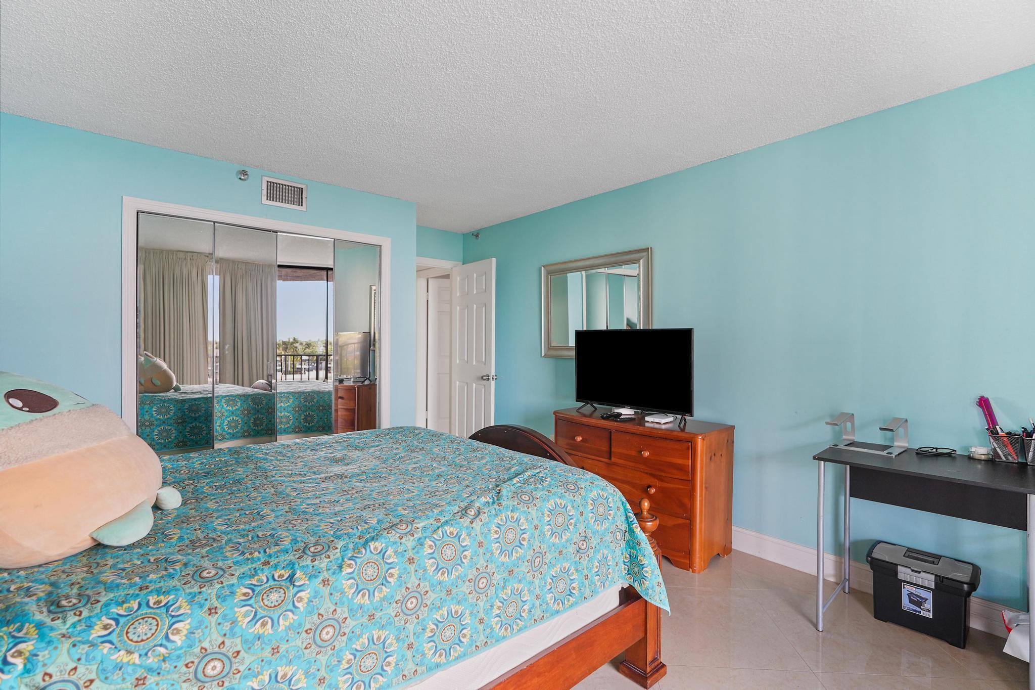 859 Jeffery Street, Unit 506 Boca Raton, FL 33487 - Photo 23 of 80 a bedroom with a bed and a flat screen tv