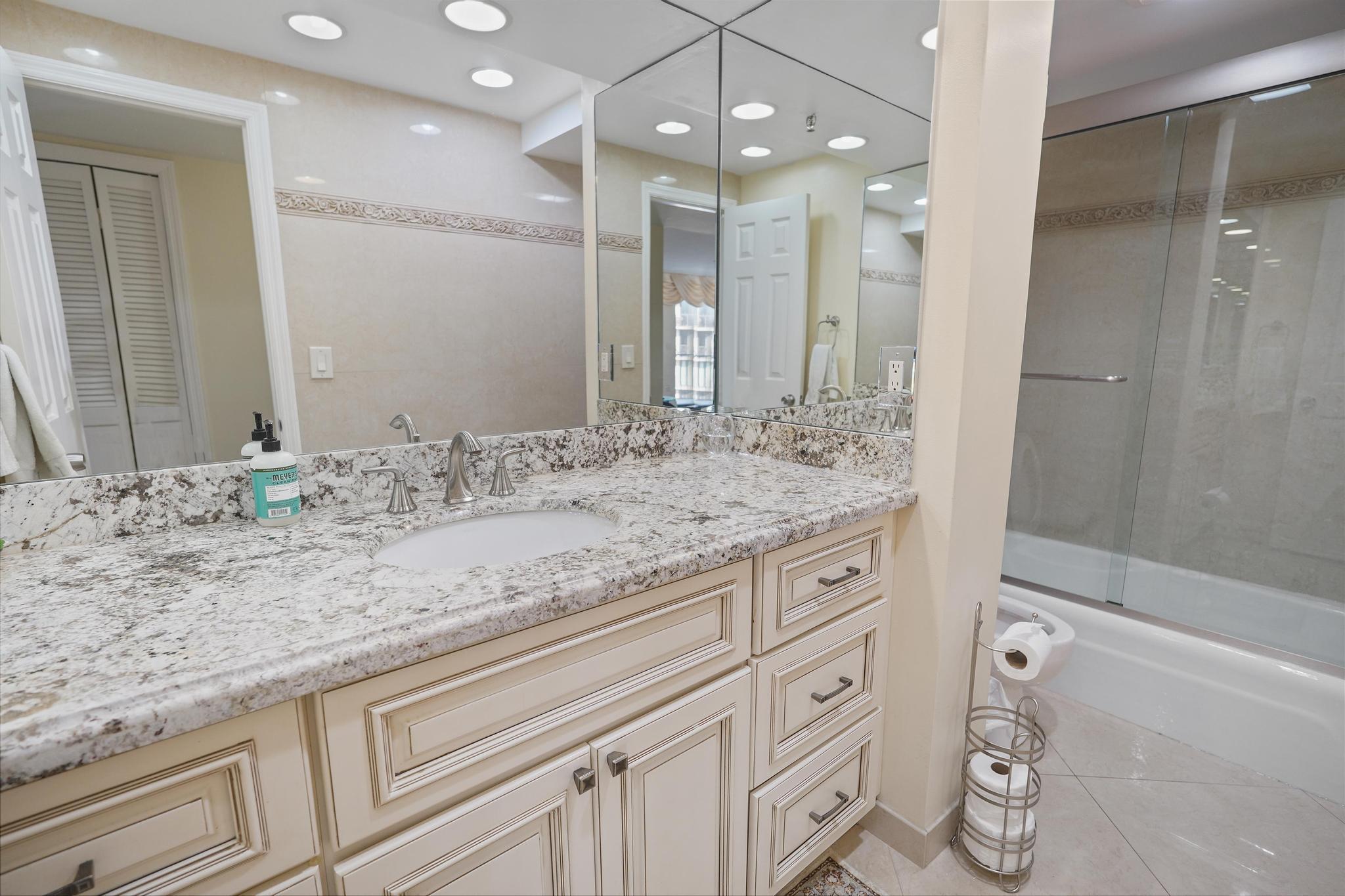 859 Jeffery Street, Unit 506 Boca Raton, FL 33487 - Photo 27 of 80 a bathroom with a granite countertop sink a large mirror and shower
