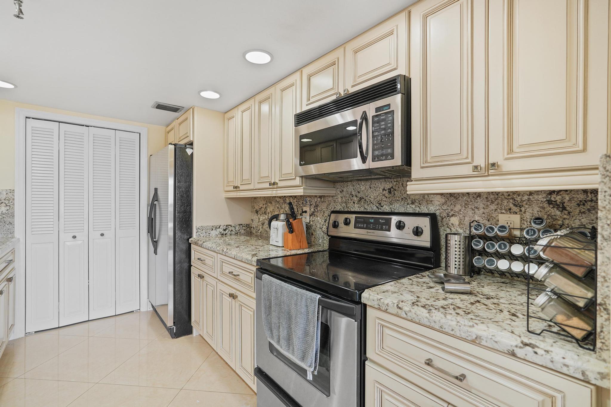 859 Jeffery Street, Unit 506 Boca Raton, FL 33487 - Photo 7 of 80 a kitchen with stainless steel appliances granite countertop a stove a sink and a microwave
