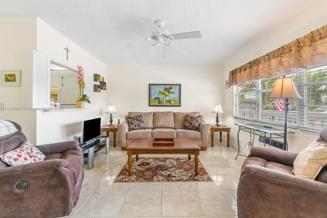 a living room with furniture a fireplace and a large window