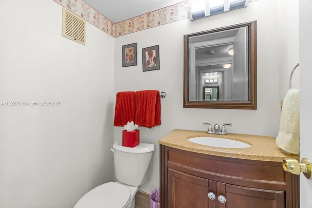 a bathroom with a toilet sink and mirror
