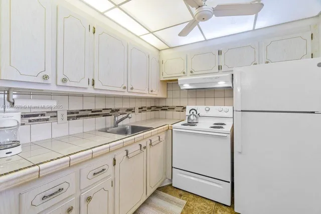 a kitchen with cabinets appliances a sink and a counter space