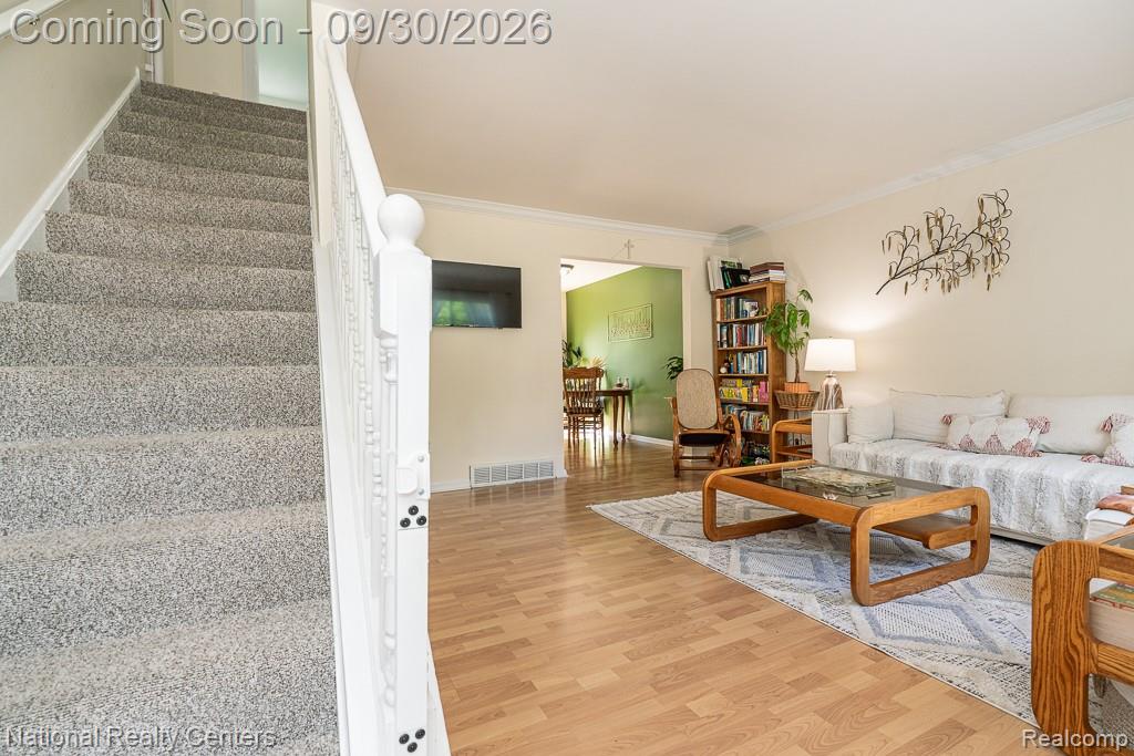67976 Van Dyke Road, Unit 15 Washington, MI 48095 - Photo 20 of 35 Wood-finish flooring, staircase with carpeted treads, white painted newel post and balusters, crown molding, and recessed light fixture