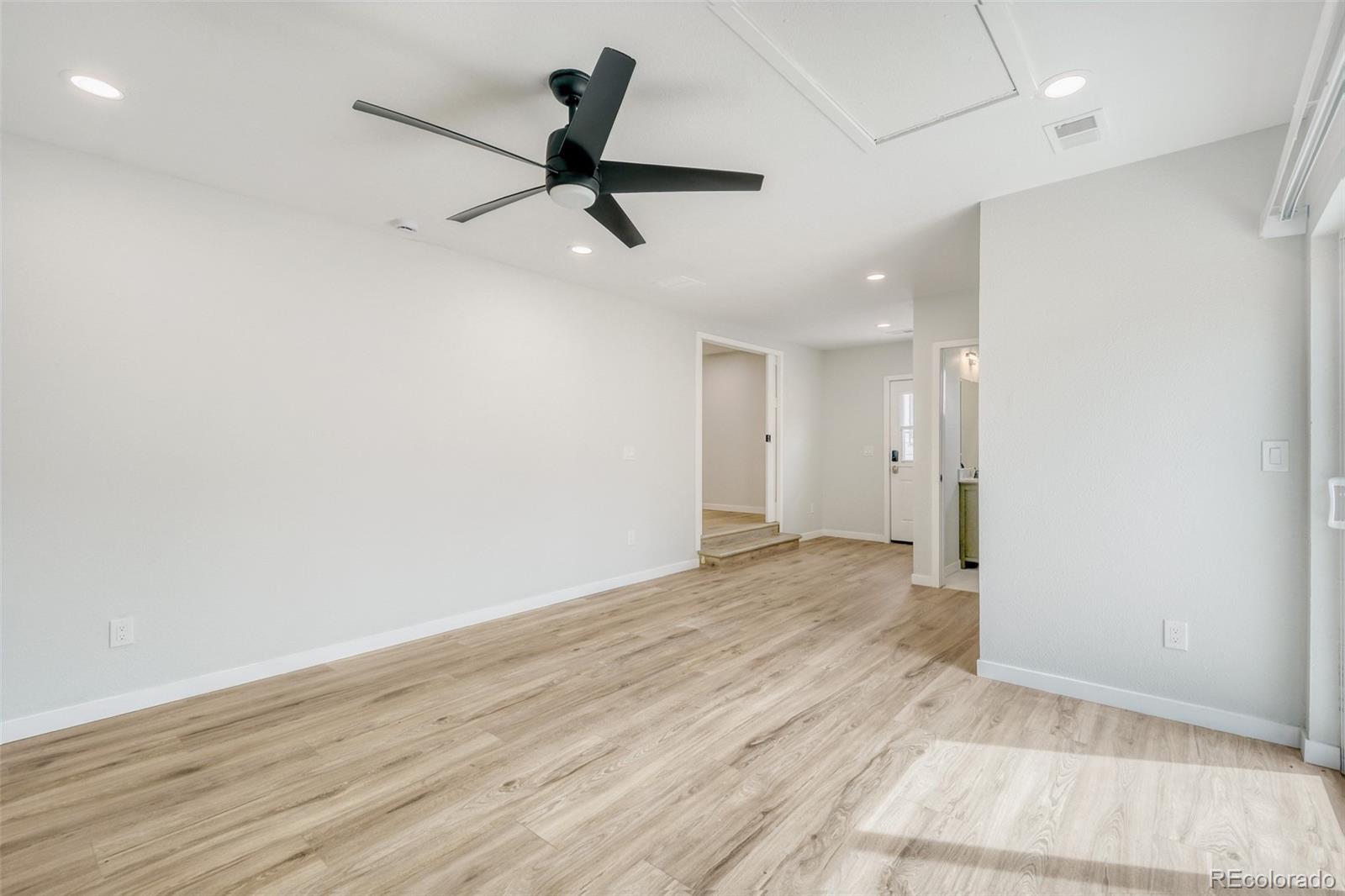 321 West Mulberry Street Fort Collins, CO 80521 - Photo 17 of 32 a view of a big room with wooden floor a ceiling fan and kitchen space