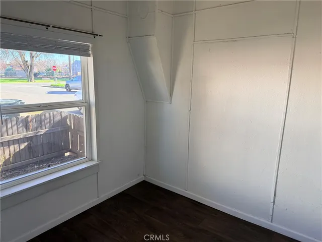a view of empty room with window and wooden floor