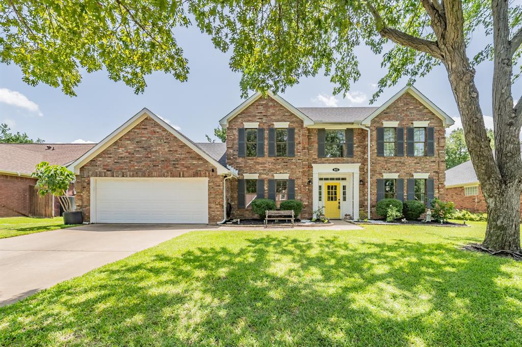 a front view of a house with a yard and trees