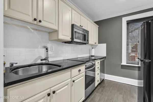 a kitchen with stainless steel appliances granite countertop a sink stove and microwave