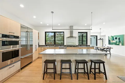 a kitchen with stainless steel appliances granite countertop a stove and white cabinets with wooden floor