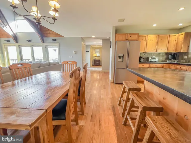 a dining room with wooden floor and chandelier