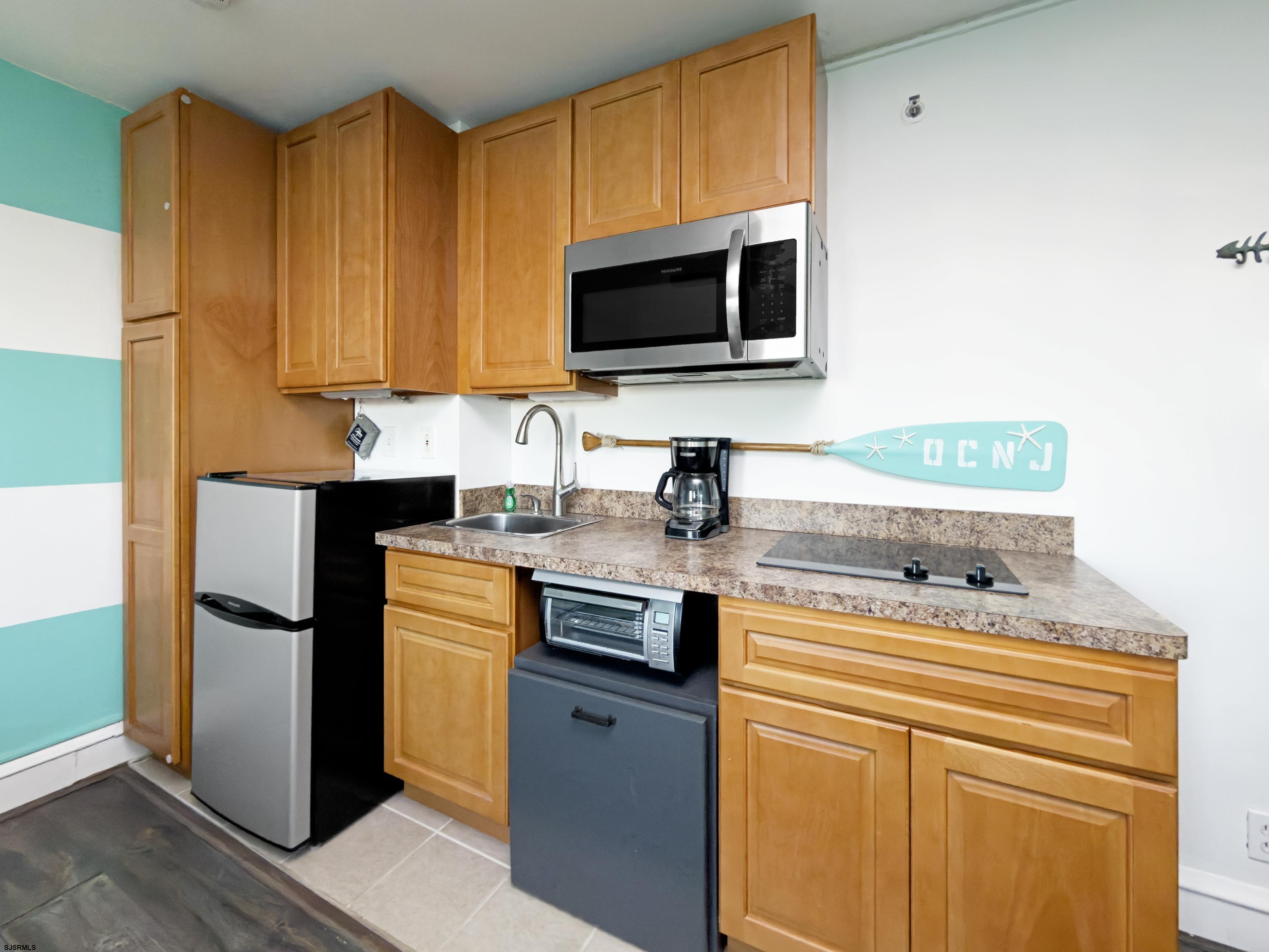 807 East 8th Street, Unit 515 Ocean City, NJ 08226 - Photo 4 of 34 a kitchen with stainless steel appliances a stove microwave and refrigerator