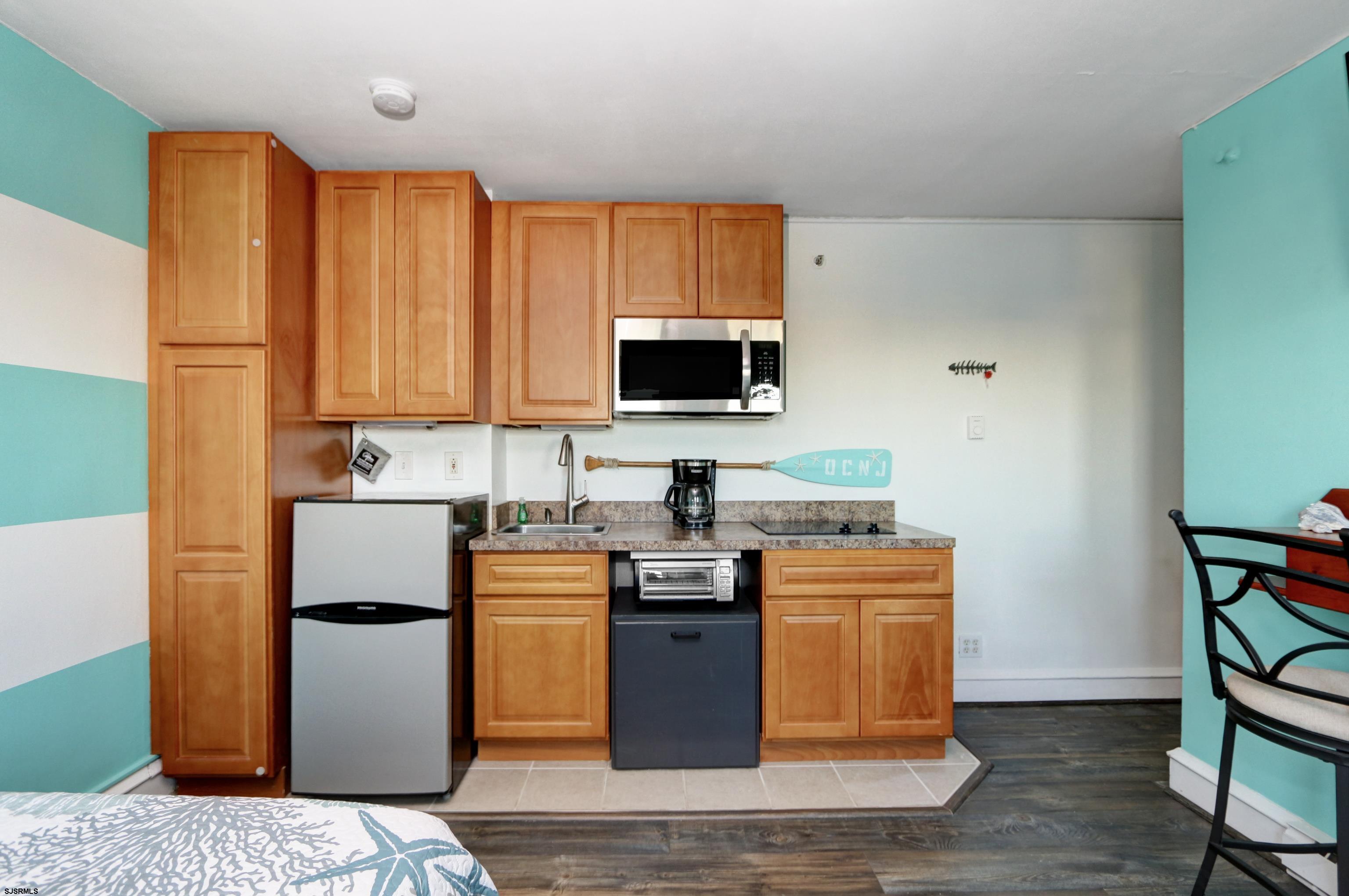 807 East 8th Street, Unit 515 Ocean City, NJ 08226 - Photo 5 of 34 a kitchen with stainless steel appliances granite countertop a stove top oven a refrigerator a sink and dishwasher with wooden floor