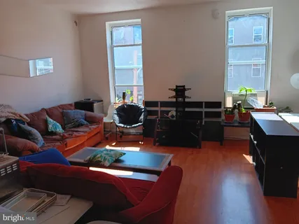 a living room with furniture and wooden floor