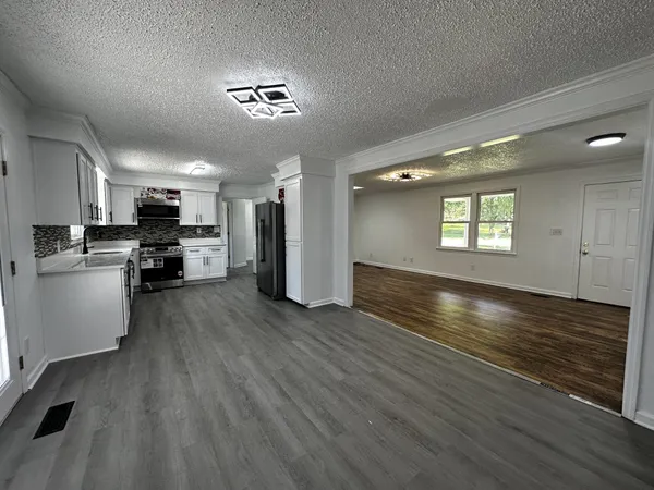 a view of an empty room with kitchen appliances and a window