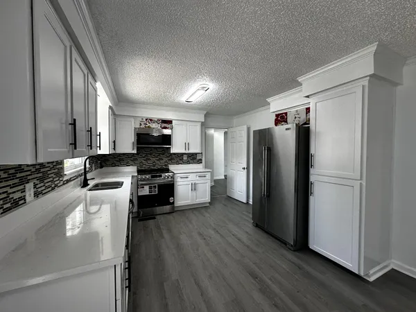 a kitchen with a refrigerator a stove top oven a sink and dishwasher