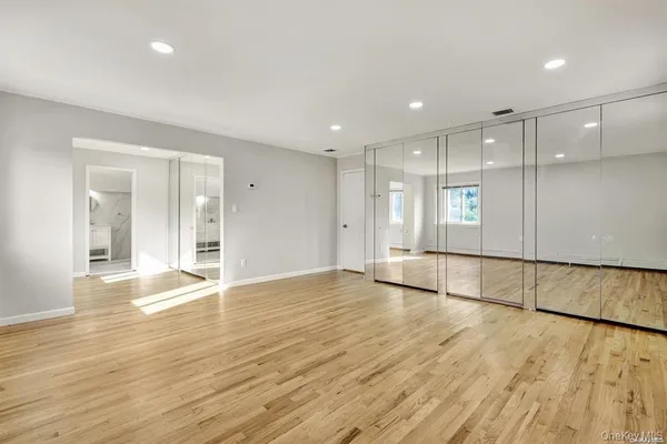 a view of an empty room with wooden floor