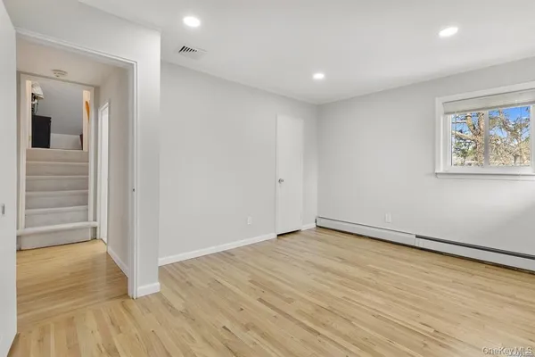 wooden floor in an empty room with a window