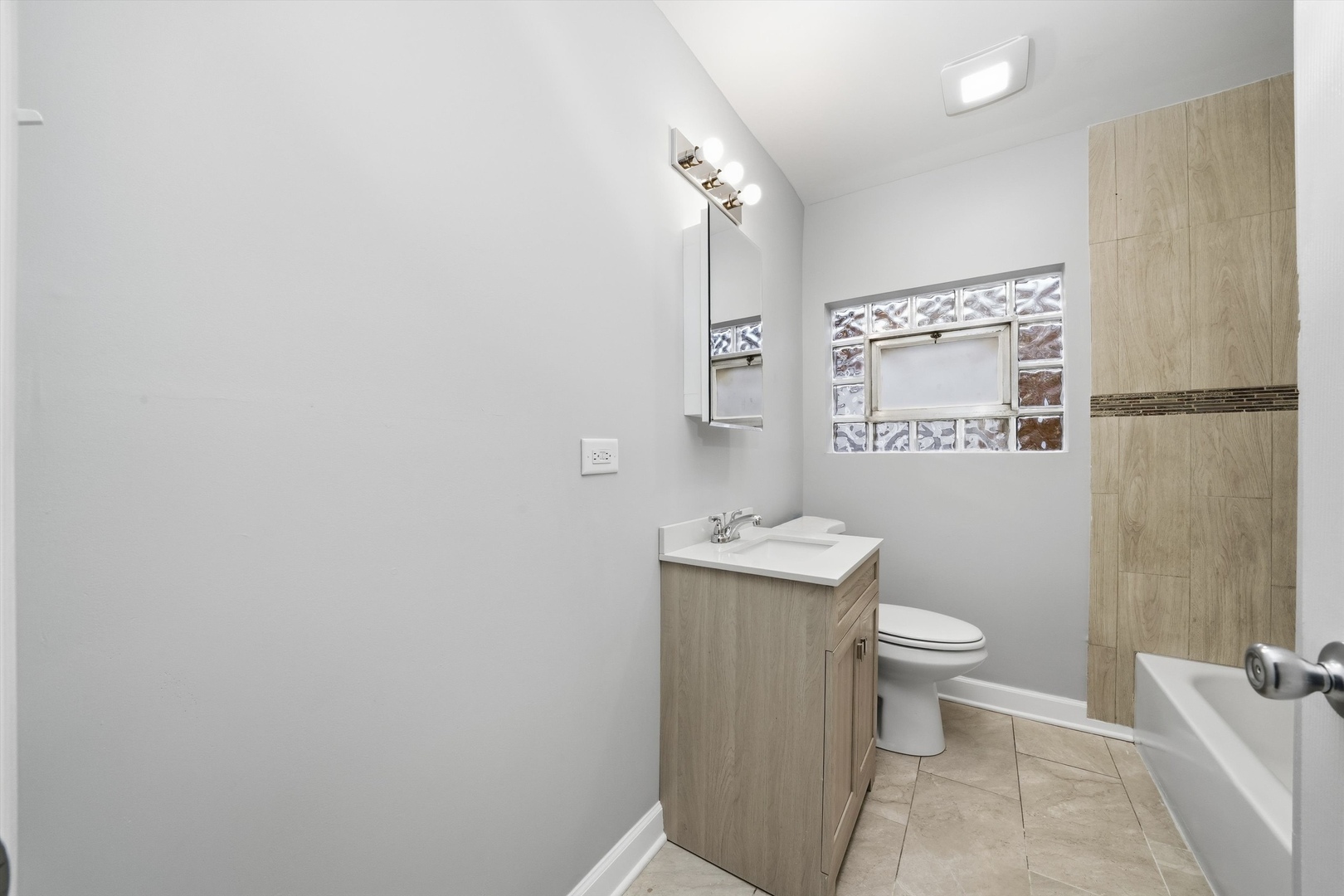 2658 West 83rd Street Chicago, IL 60652 - Photo 14 of 37 a bathroom with a toilet a sink and mirror