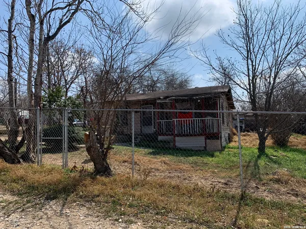 a view of house with backyard space and wooden fence