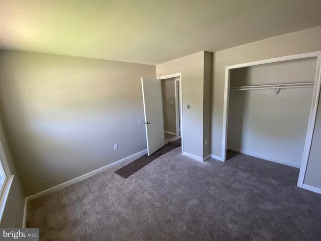 an empty room with wooden floor and stairs